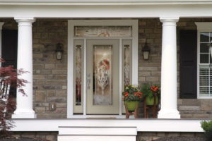 Front entry way of suburban home with light tan front door.